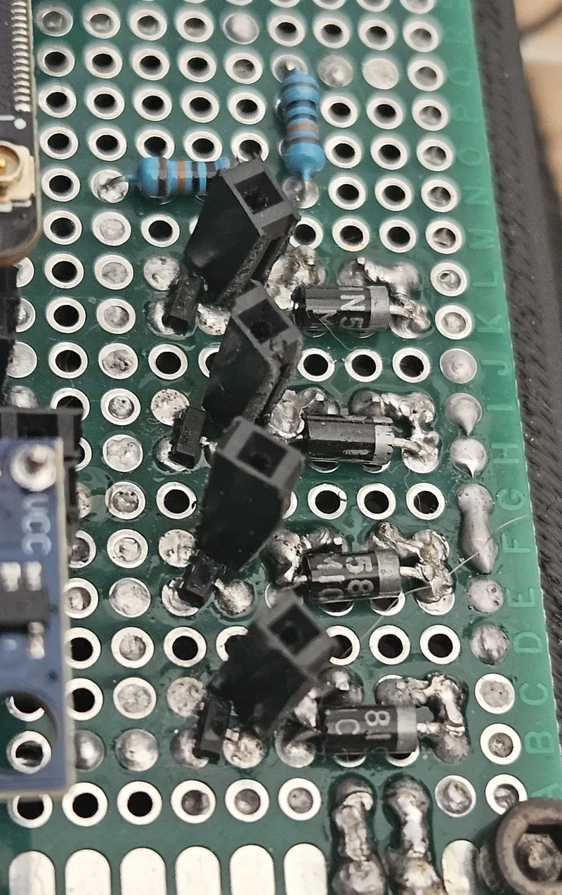 Motor-driver MOSFETs (SI2302) with gate pull-down resistors. They were added after floating gates at boot caused inductive spikes that killed the first ESP32 — the classic lesson that motivated the custom PCB.