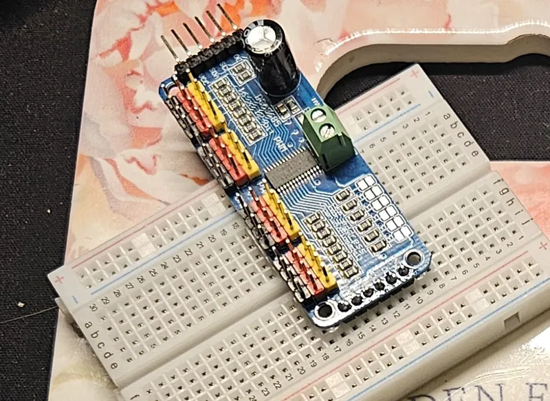 The PCA9685 16-channel PWM driver during bring-up — it generates the pulses for all five servos over I2C, off-loading timing from the MCU.
